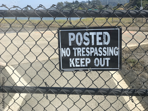 No Trespassing Keep Out sign along the fence