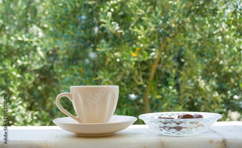 Turkish Coffee with sweet cookies on nature background. Low view composition. Closeup shot of hot Greek Coffee. Beautiful tasty traditional brown drink of Turkish culture. Enjoy concept photo