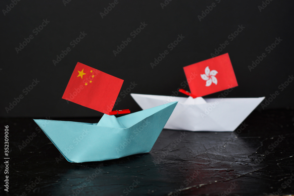 paper ship with national flag of china and hong kong, concept of conflict, shipment or free trade agreement paper ship with national flag of china and hong kong, concept of conflict, shipment or free trade agreement