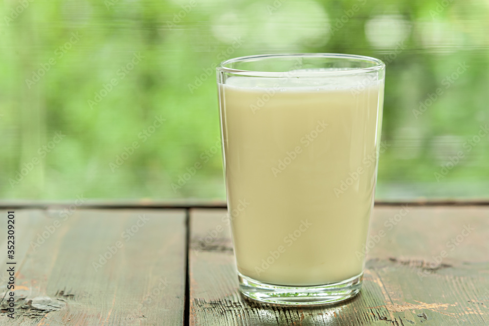 glass of fresh organic milk on a wooden table near the window glass of fresh organic milk on a wooden table near the window