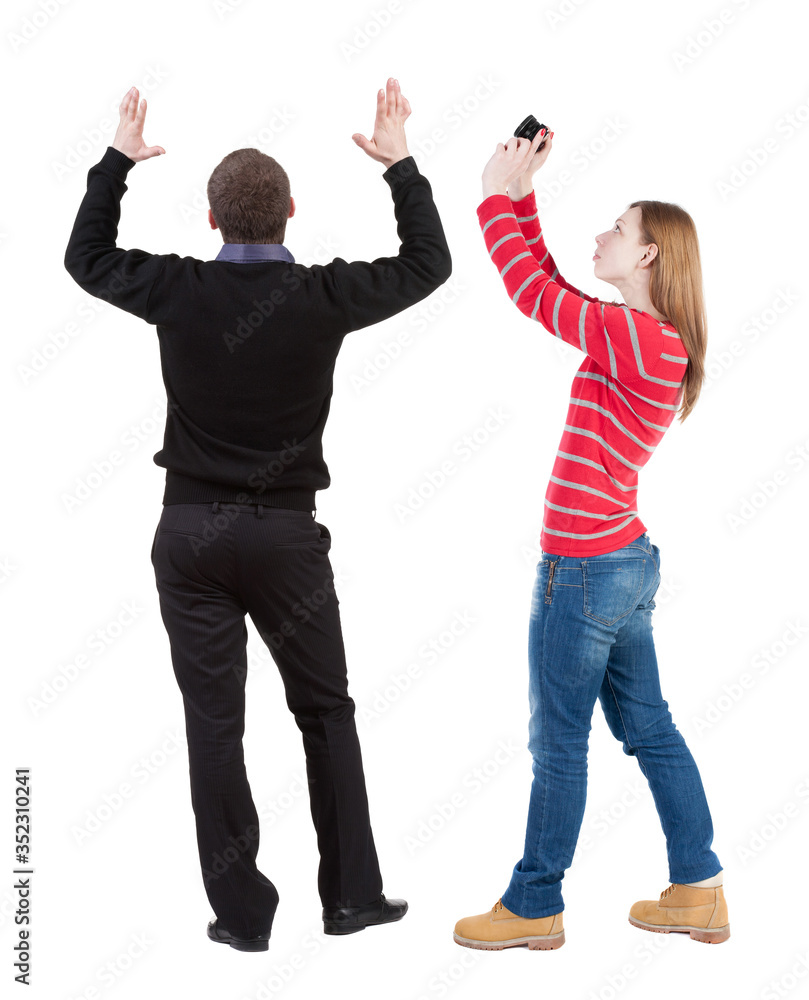 Fototapeta premium Back view of couple in sweater with mobile phone.