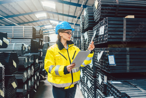 Woman worker checking the inventory in a steel warehouse photo