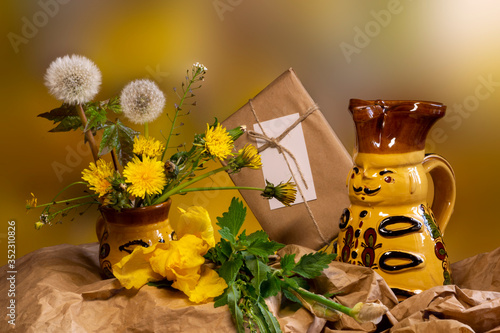 still life with flowers. spring composition. a small bouquet of dandelions and yellow iris.  photo