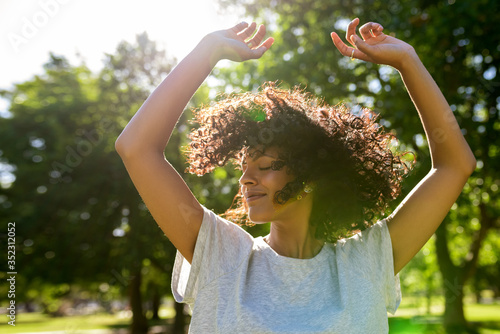 Carefree woman dancing in a park on a sunny afternoon