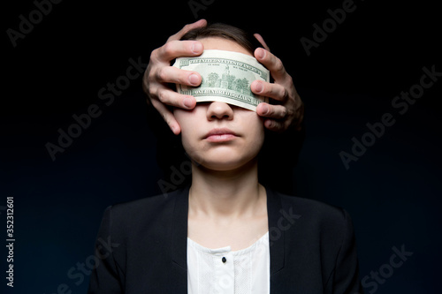 Business woman blinded by money. Dollars close her eyes