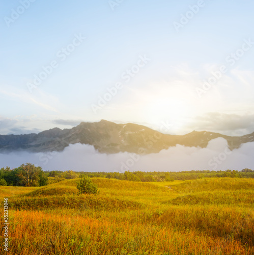 mountain valley with grassland at the sunset