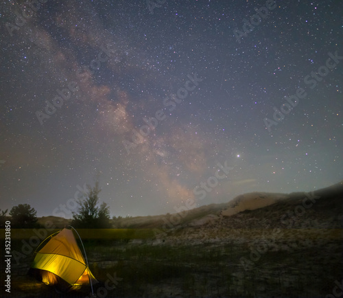 night hiking travel scene, touristic tent under a starry sky with milky way
