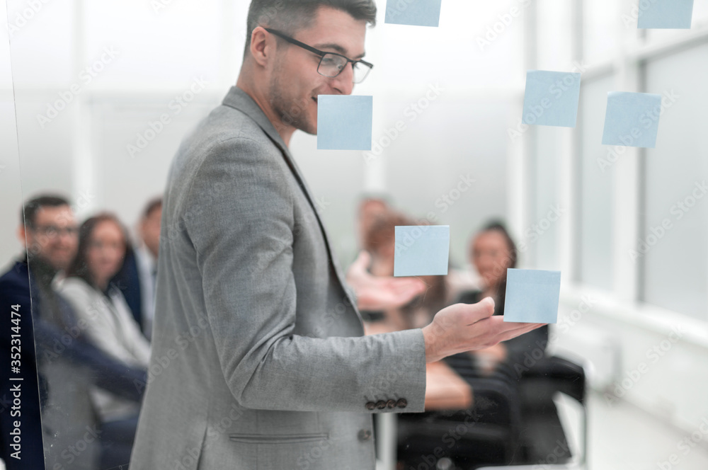 head of the project, pointing to the sticky notes during a work meeting