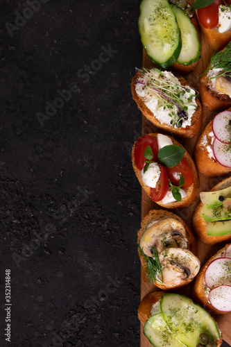 Italian bruschetta with tomatoes, mushrooms, mozzarella cheese and herbs on a cutting Board 