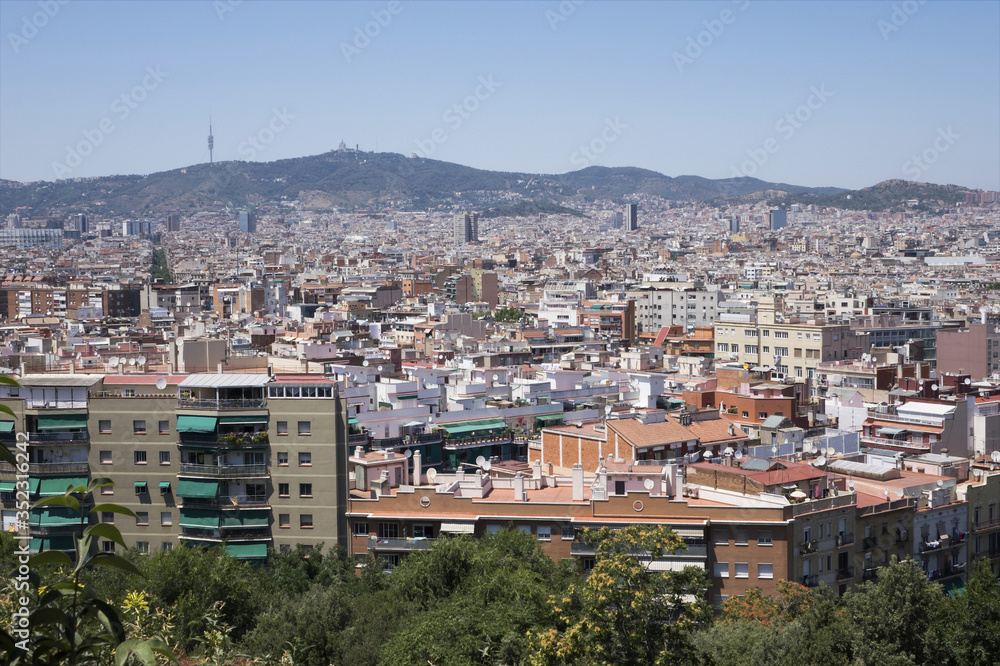 View of roofs of Barcelona surrounded with mountains from the hill of Montjuic