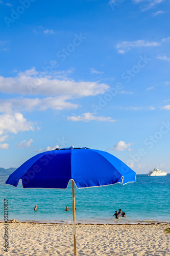 Bright blue beach umbrella on a sunny day in Anguilla  Caribbean