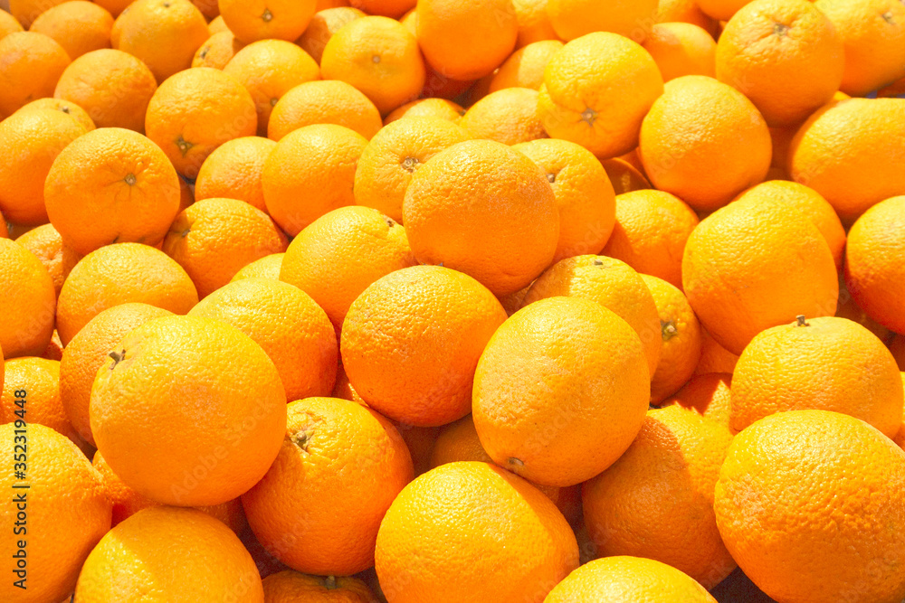 A pile of bright, juicy oranges is laid out on the counter in the store. The concept of replenishing vitamins from a natural product, a culinary ingredient, sun, warmth and summer. A pile of bright, juicy oranges is laid out on the counter in the store. The concept of replenishing vitamins from a natural product, a culinary ingredient, sun, warmth and summer.
