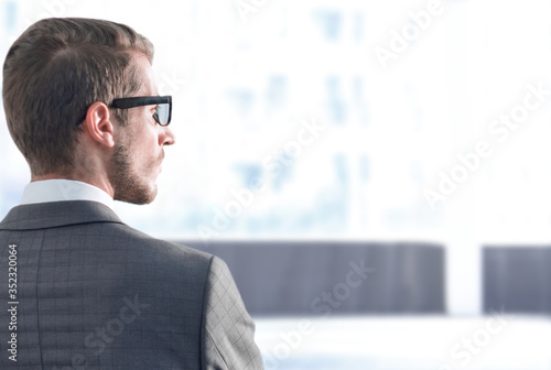 rear view.businessman standing near the office window