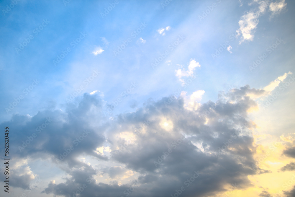 Beautiful background with blue sky covered with clouds and tender yellow sunlight behind. Beautiful background with blue sky covered with clouds and tender yellow sunlight behind.