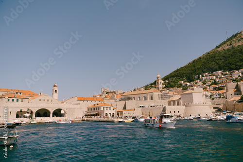 The old port harbor is porporela, near the walls of the old town of Dubrovnik, Croatia. A ship with tourists goes on an excursion.