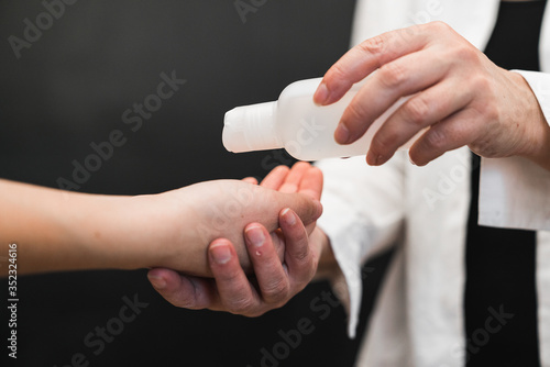 Washing your hands with alcohol gel or antibacterial soap. Disinfectant gel. Doctor pouring alcohol disinfectant on his patient's hands. Coronavirus devices. Health care. Washing your hands.