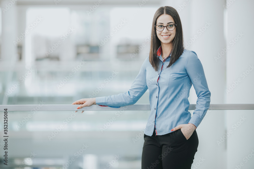 Smiling entrepreneur waiting for a meeting in an open space area of the office Smiling entrepreneur waiting for a meeting in an open space area of the office