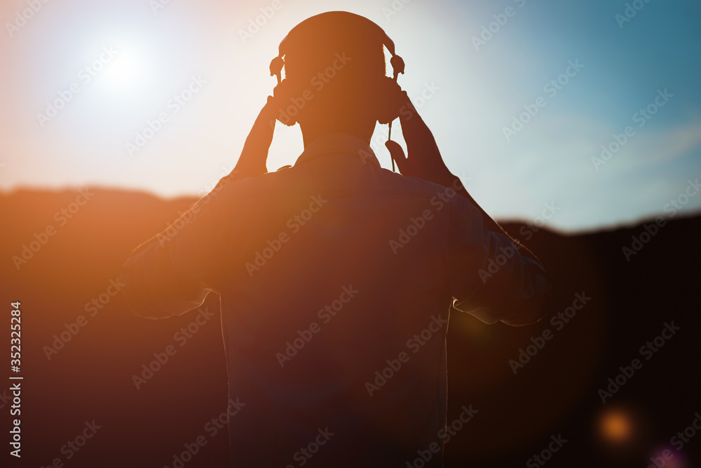 stylish bearded man in headphones listening to music - obrazy, fototapety, plakaty 