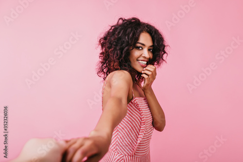 Romantic portrait of cute friendly girl with snow-white smile. Tanned model posing for camera