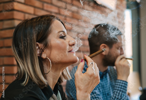 Close-up of a woman in a restaurant enjoying tobacco smoke