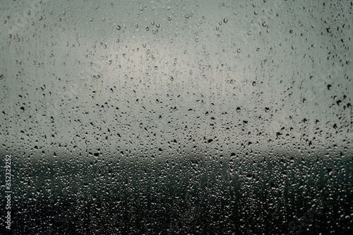 Raindrops on glass, view from the window, heavy rain, bad weather, loneliness, isolation. The texture of the wet surface, background, beautiful wallpaper. Nature is crying.