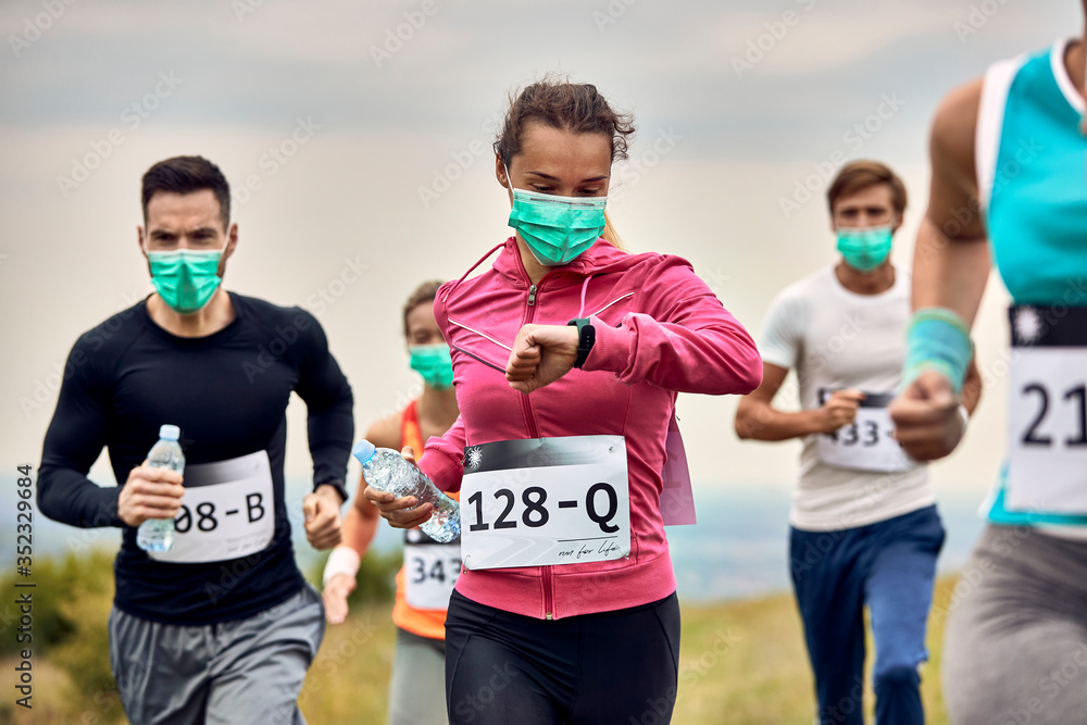 Marathon runner using smart watch while participating in a race.