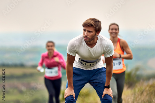 Young marathon runner catching breath after the race in nature.