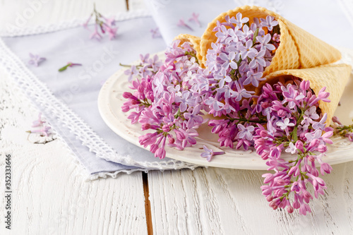 View purple lilacs. Shallow depth of field with lilacs and lilac leaves on wooden table