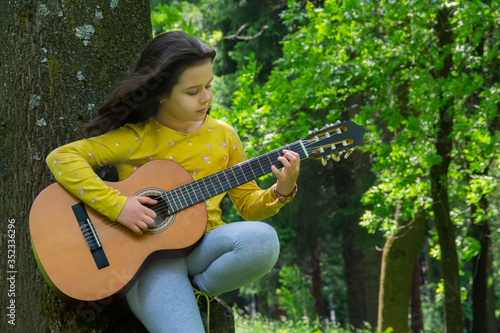Girl playing the guitar in nature