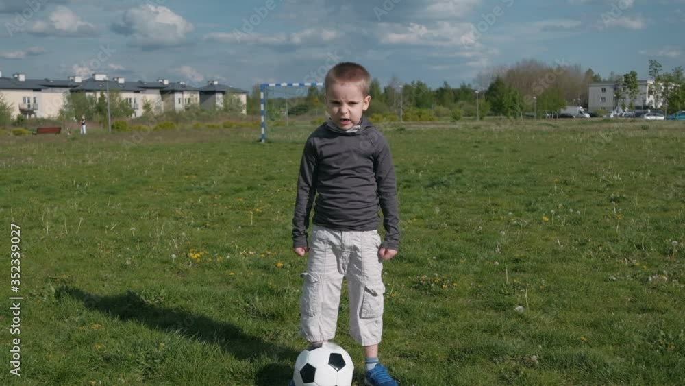 Kid with soccer ball screaming from top of his lungs. Zoom in Kid with soccer ball screaming from top of his lungs. Zoom in