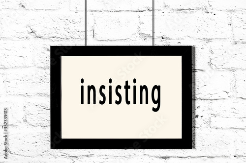Принти на полотні Black frame hanging on white brick wall with inscription insisting