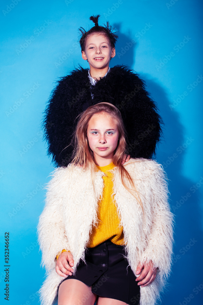 young and pretty fashion models boy and teenage girl posing cheerful on blue background, lifestyle people concept young and pretty fashion models boy and teenage girl posing cheerful on blue background, lifestyle people concept