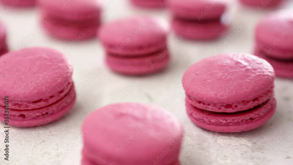 Close-up view of many rows of pink macarons macaroon on white background. Classical French dessert. Close-up view of many rows of pink macarons macaroon on white background. Classical French dessert.