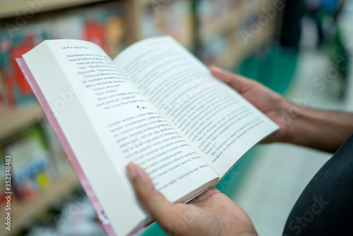 man holding a book in his hand at the supermarket