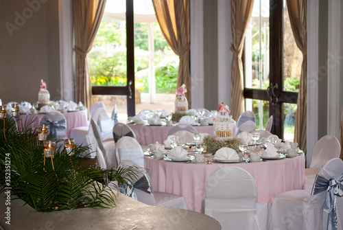 Table served in city hotel, birthday celebration, patisserie and themed decoration, interior with tables and tablecloth.