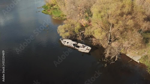 4K quality aerial cloudy autumn day video scenic view of wode river, yellow leafed trees, old abandoned deserted boat and hills in suburb area in northern Europe photo