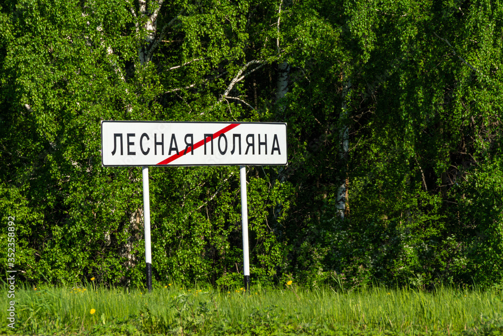road sign end of town Lesnaya Polyana or Forest Glade, a satellite city of Kemerovo, summer green birch forest and grass