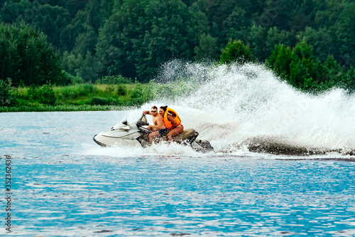 Fotografie Man and woman ride a jet ski