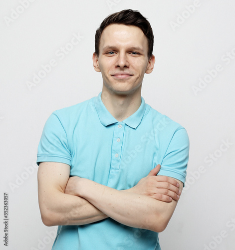 young man with emotions on his face a grey background
