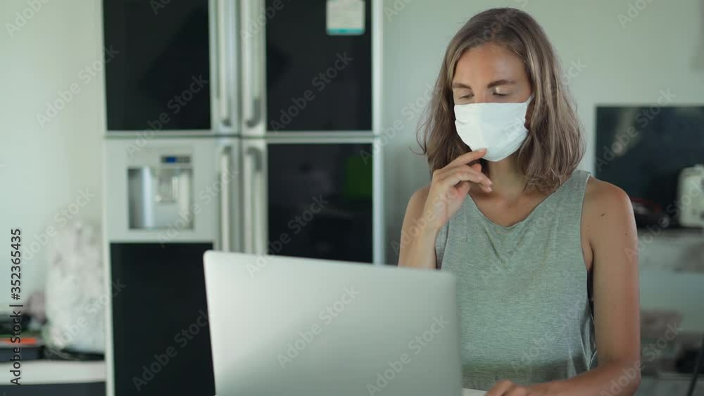Blonde girl wearing mask and working at home in quarantine COVID-19 Blonde girl wearing mask and working at home in quarantine COVID-19