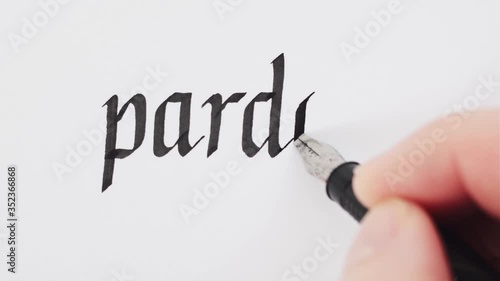 Handwritten word Pardon. Male hands writing with a pen. Calligraphy closeup.