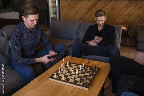 Men play chess in a stylish loft cafe with a modern design.
