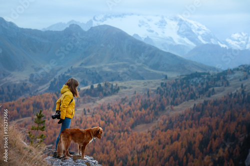 person with a dog in the mountains. travel, hiking with a pet. Nova Scotia retriever with a girl.
