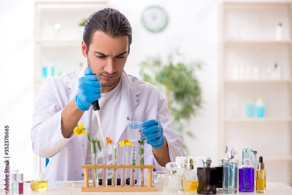 Young male chemist in perfume synthesis concept Young male chemist in perfume synthesis concept