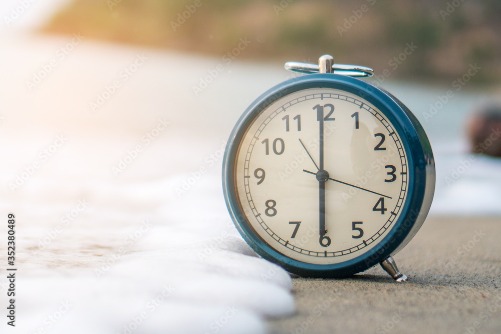 Selective focus of alarm clock with nature background. Selective focus of alarm clock with nature background.