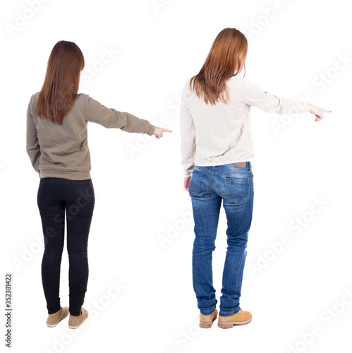 Back view of two young woman photographed on a mobile phone in sweater.