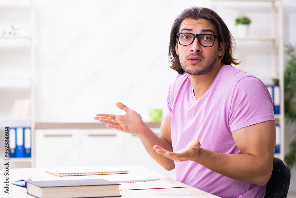 Young male student preparing for exams at classroom Young male student preparing for exams at classroom