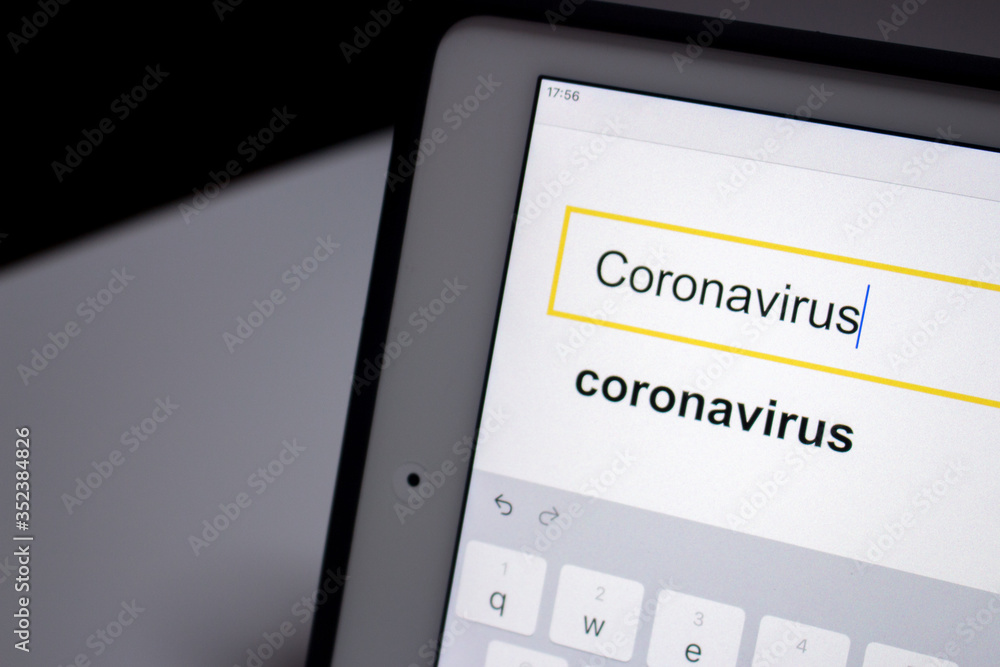 Coronavirus in search bar in search engine on tablet on table. Coronavirus in search bar in search engine on tablet on table.