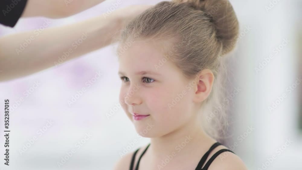 Young dance teacher fixing hairstyle to her student Young dance teacher fixing hairstyle to her student