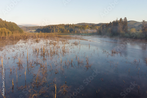 Fototapeta Naklejka Na Ścianę i Meble -  Morning lake with steam at sunrise, morning landscape. Shot from a height